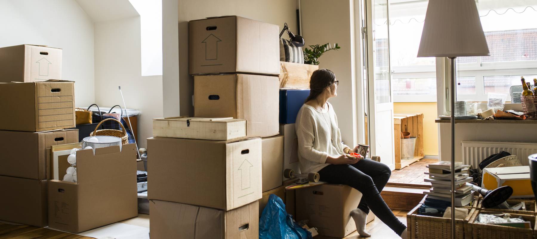 Woman sitting on box while moving house.
