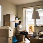 Woman sitting on box while moving house.