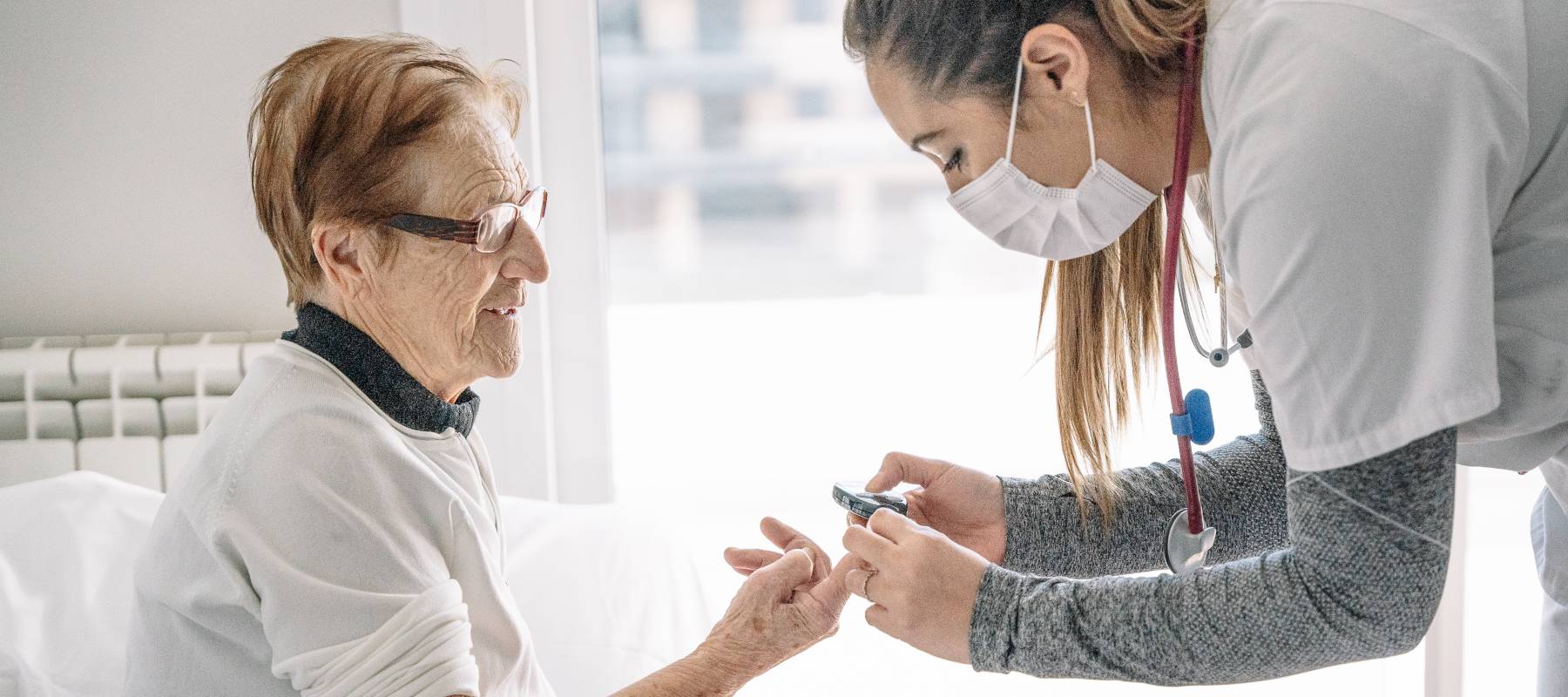 A medical professional takes an elderly woman's blood pressure.