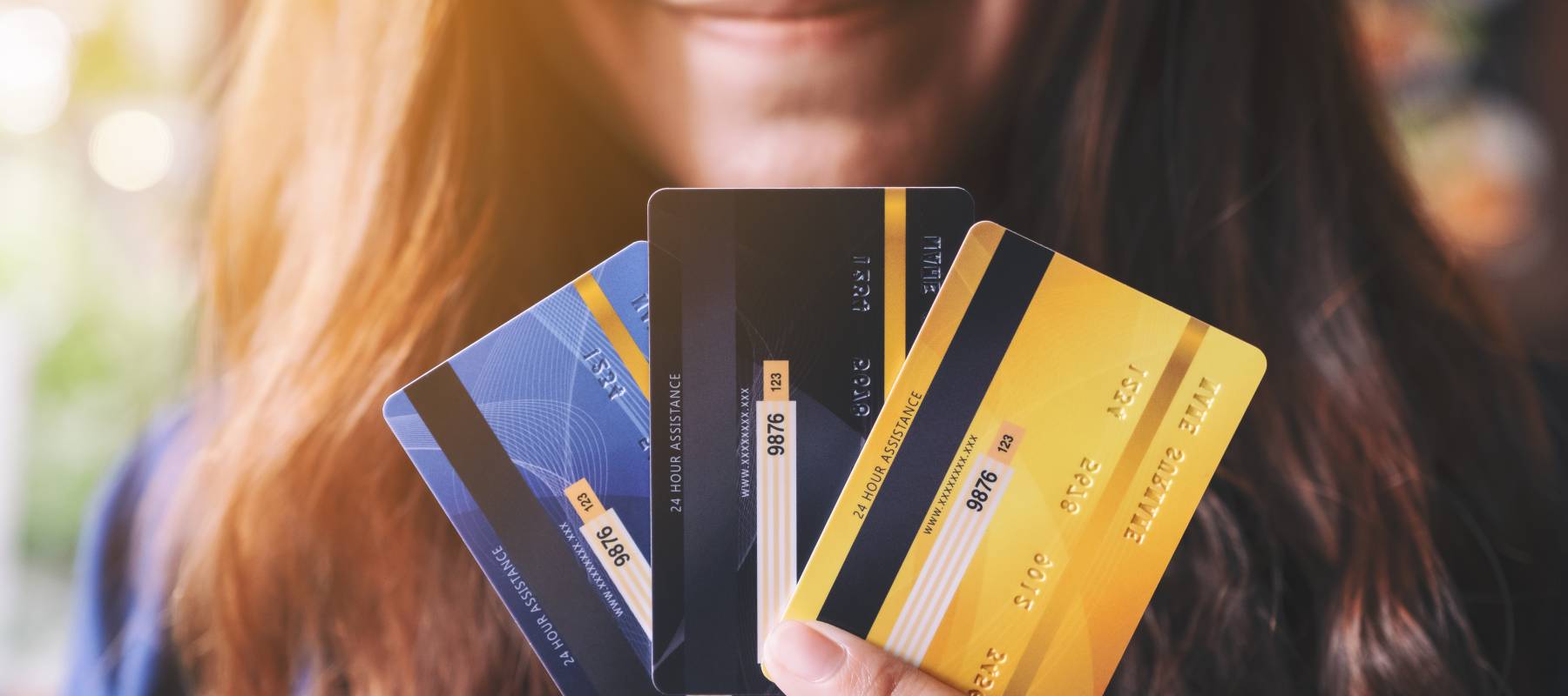 A woman holding up credit cards.