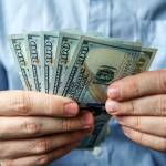 man holding five hundred US dollars.
