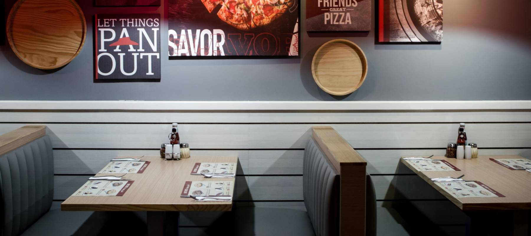 DUBAI UNITED ARAB EMIRATES - 9 SEPTEMBER 2017: Interior design in low light in Pizza Hut restaurant franchize of empty table, conceptual. Great Lives. Great Friends. Great Pizza