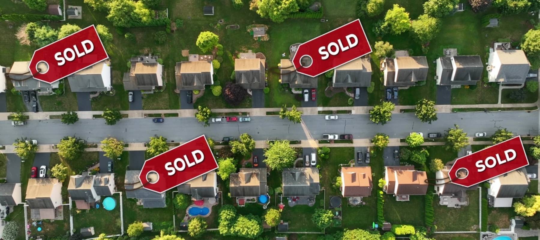 aerial of a neighborhood with sold signs over several houses