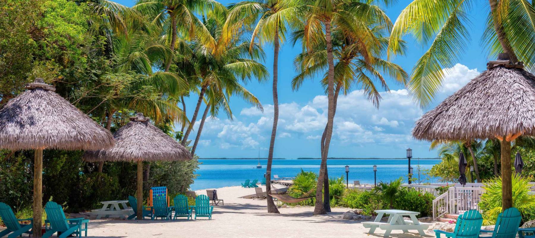 Palm trees and umbrellas in beautiful beach in tropical island resort, Key Largo. Florida.
