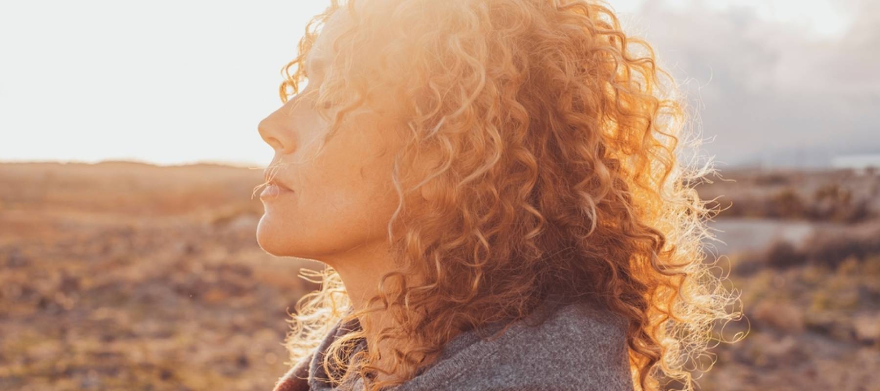 side view portrait of attractive woman closing eyes and enjoying nature in outdoor leisure activity alone