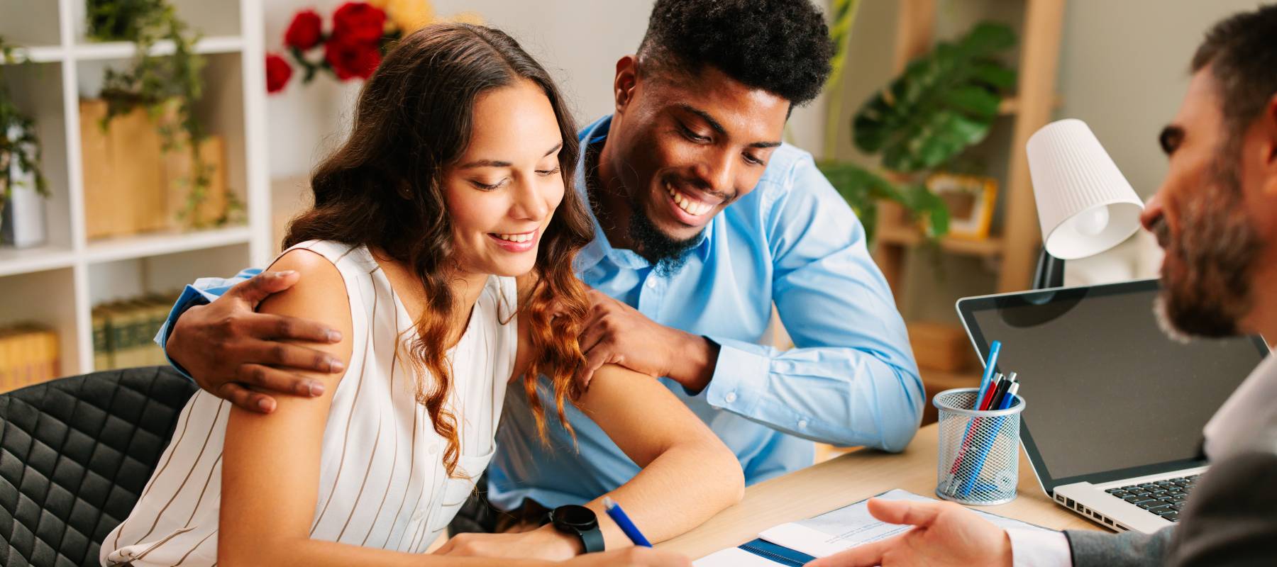 A young couple sign a contract with an agent.