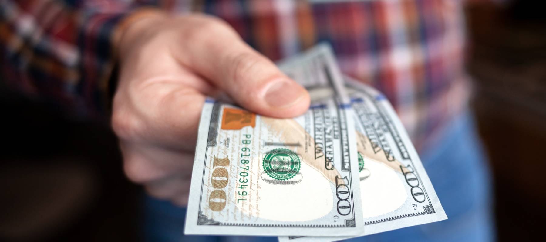 Someone holding out cash money.