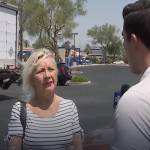 Reporter speaking to blonde woman in parking lot.