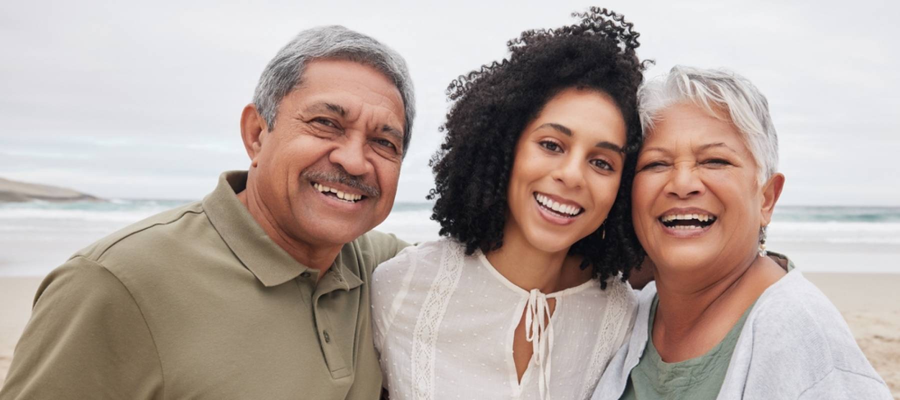 happy woman and senior parents at beach on holiday