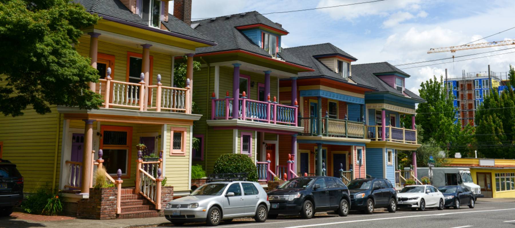Cars are parked in front of historic houses in Portland