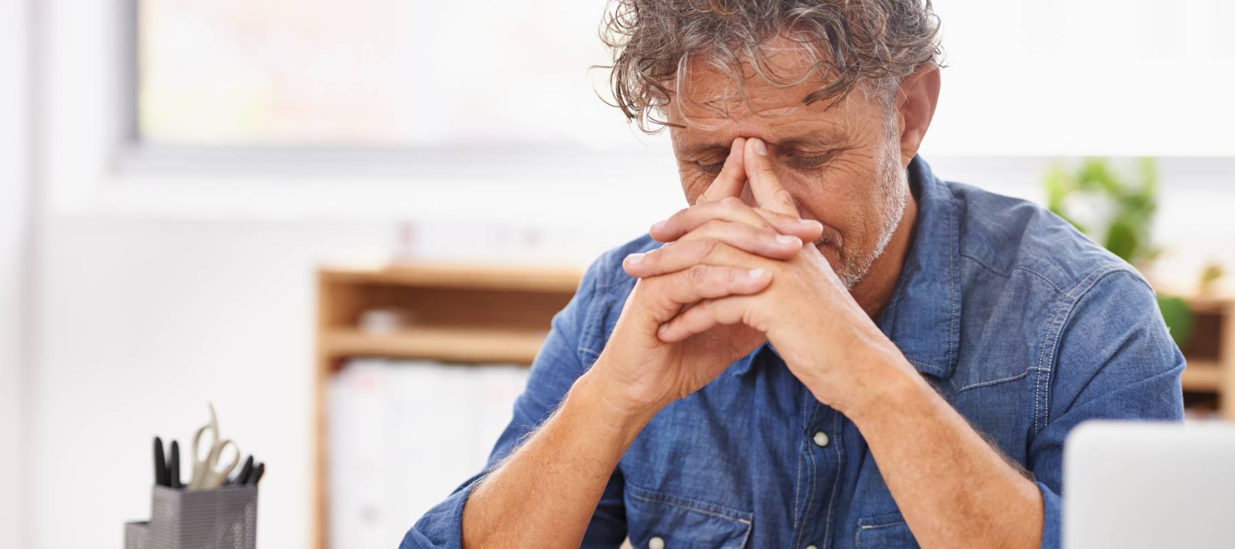 A mature man is stressed after looking at his credit card bills.