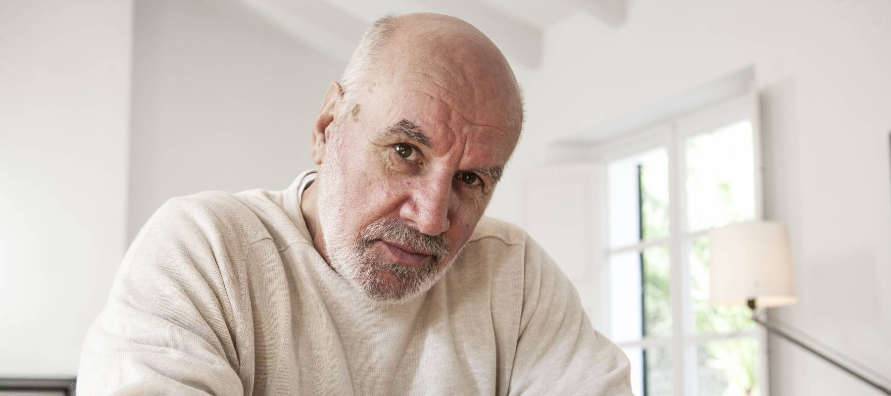 Portrait of senior man, pensive expression, staring directly at camera.