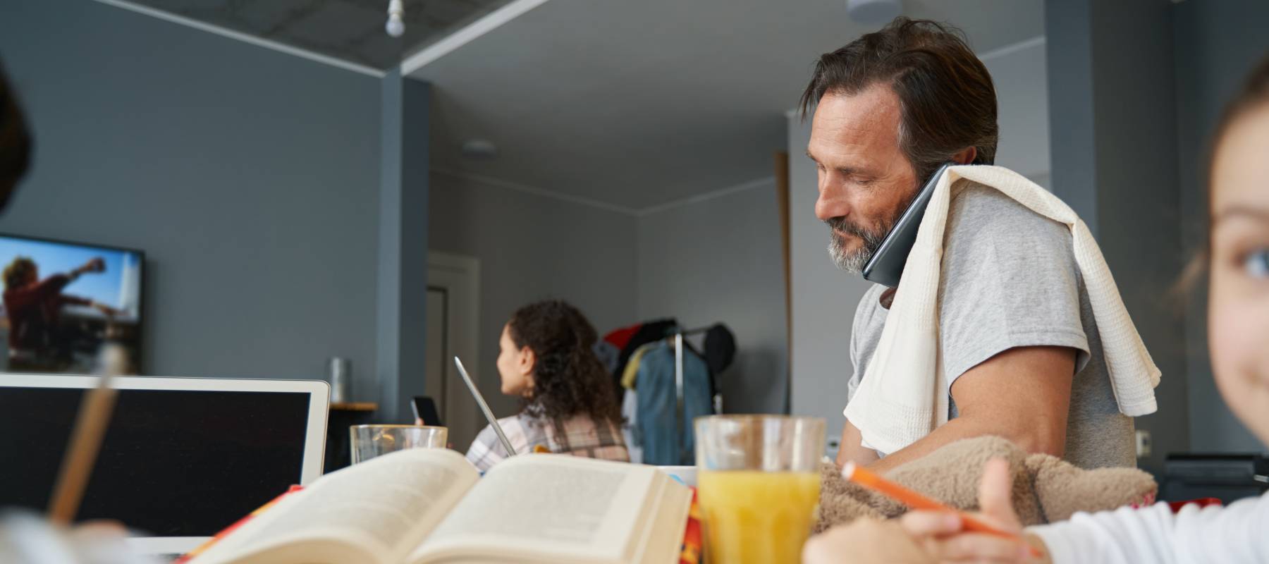 Man talking on phone from home while working at table