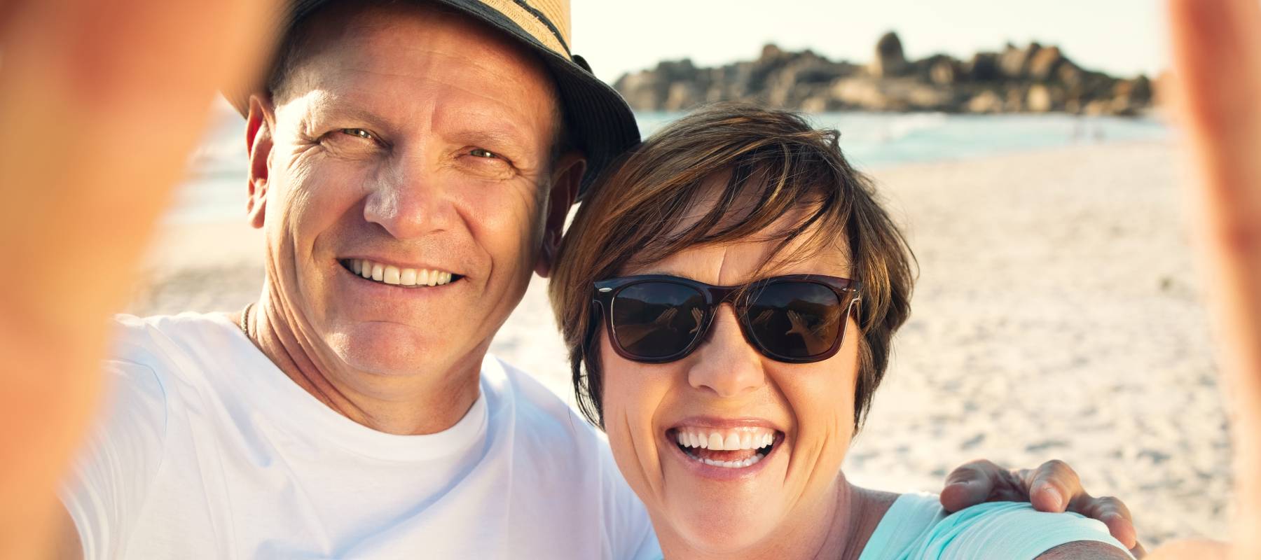 Mature couple takes a selfie on the beach.
