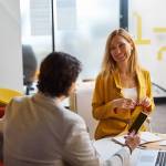 blonde woman keeping smile on her face while having pleasant conversation