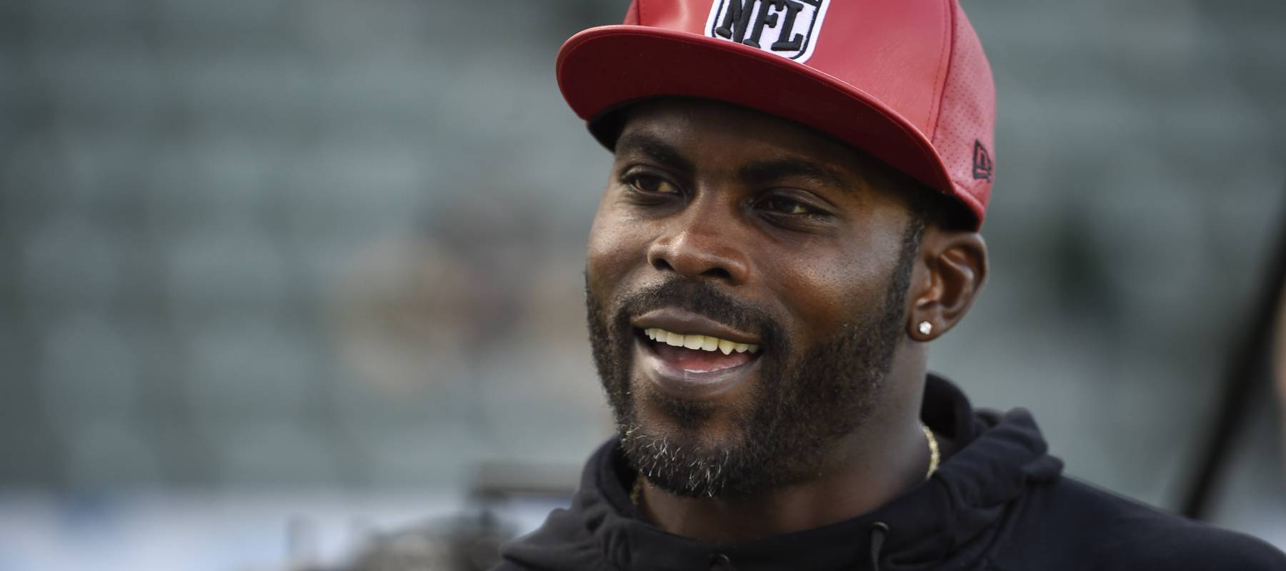Michael Vick stands on the field before an NFL game between the Pittsburgh Steelers and Los Angeles Chargers at Dignity Health Sports Park in Carson, California, Oct. 13, 2019.