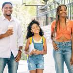 A father and mother take their daughter to school.