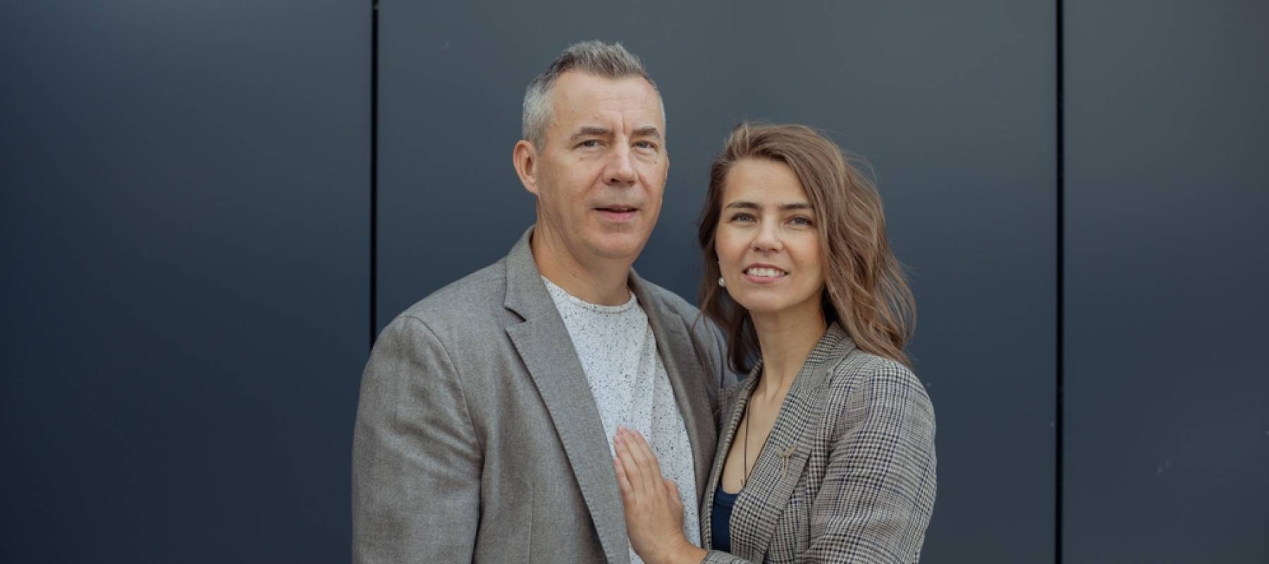 Romantic smiling couple of senior gray haired man and young blond woman embracing