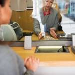 people, withdrawal, saving and finance concept - clerk with cash money and customer at bank office or currency exchanger