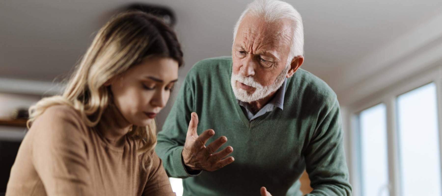 Mature father arguing with his adult daughter at home