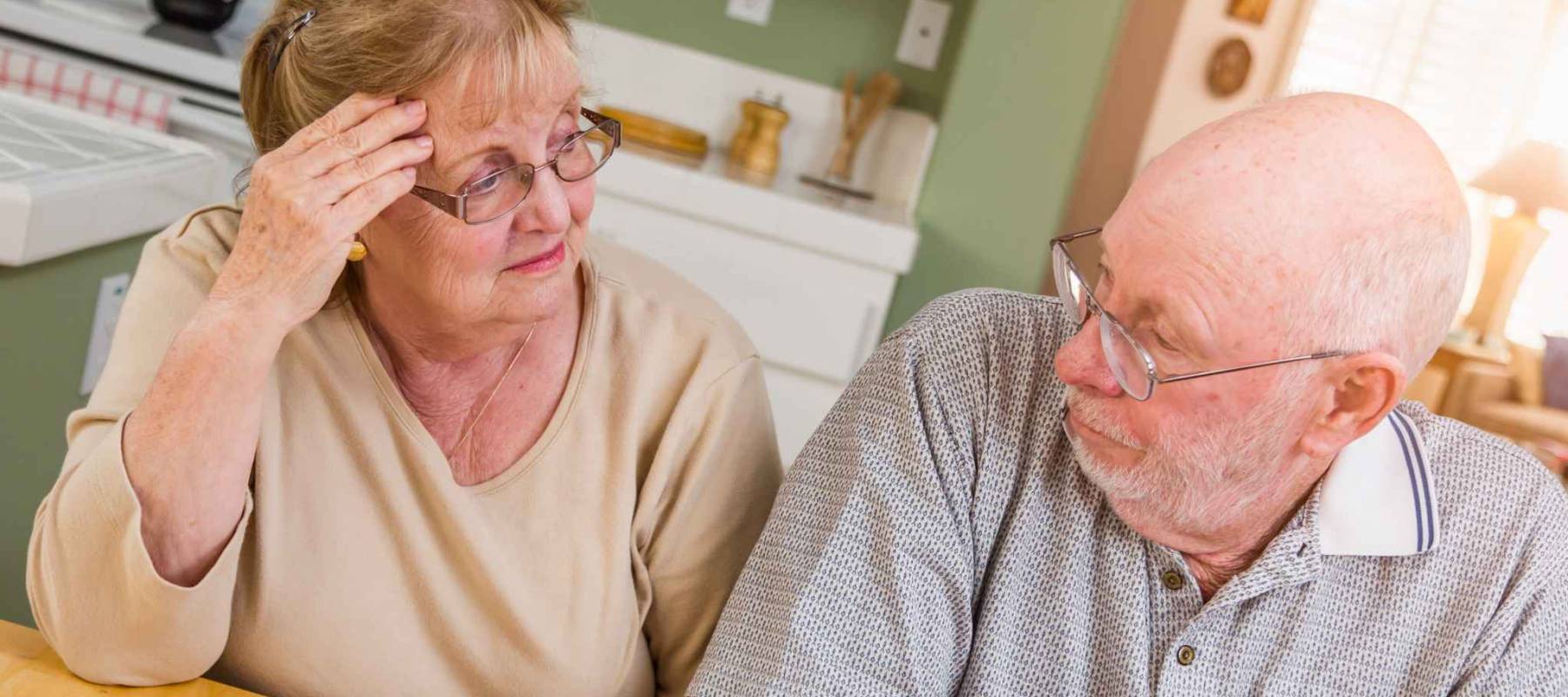 Senior Adult Couple Going Over Documents in Their Home with Agent At Signing.