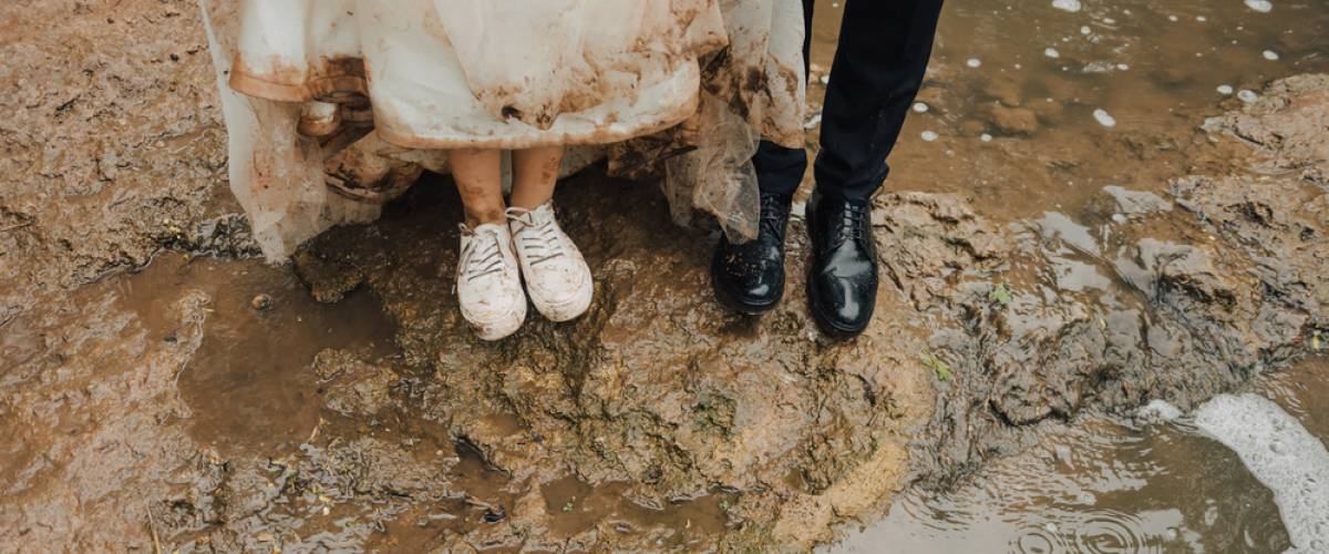 bride and groom with muddy dress and shoes