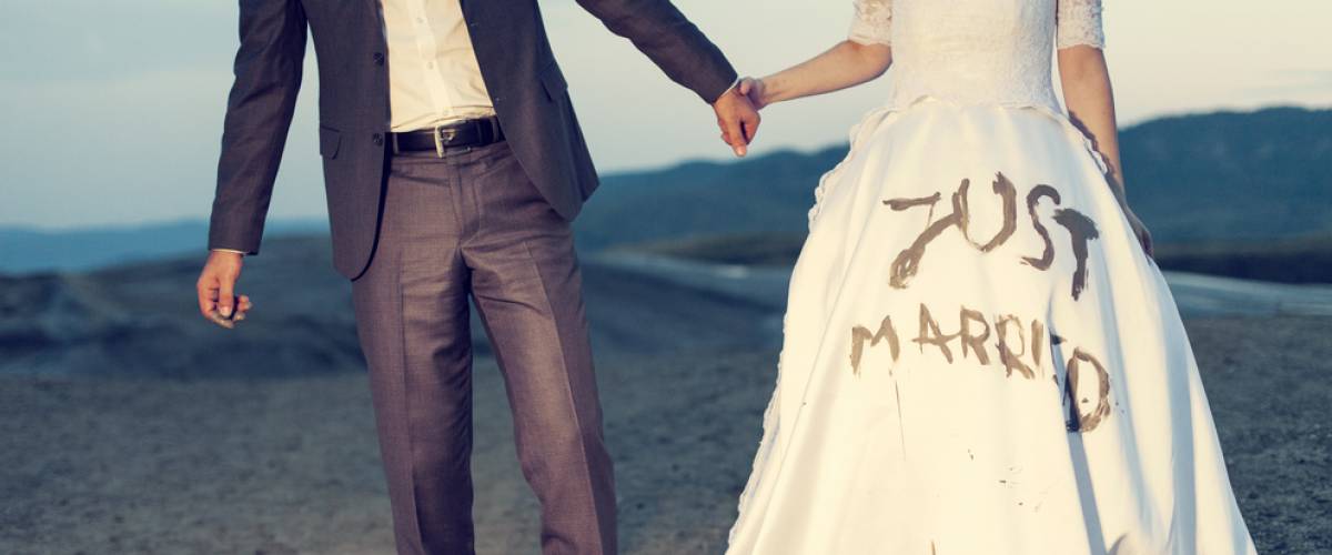 bride with just married painted haphazardly on her dress