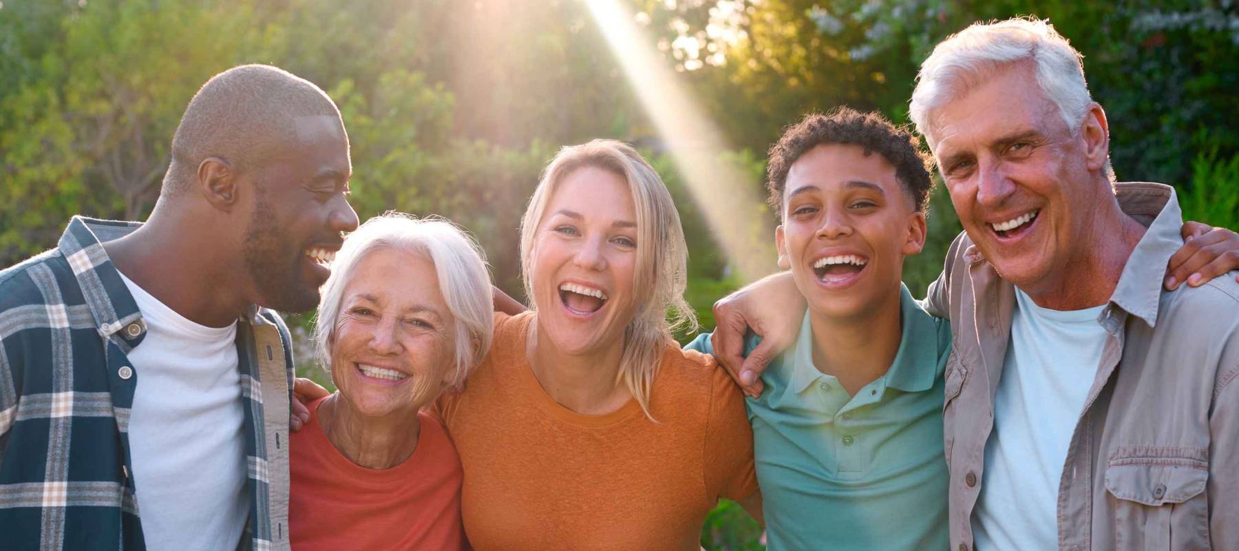 Portrait Of Three Generation Family Laughing And Smiling Sitting Outdoors On Walk In Countryside