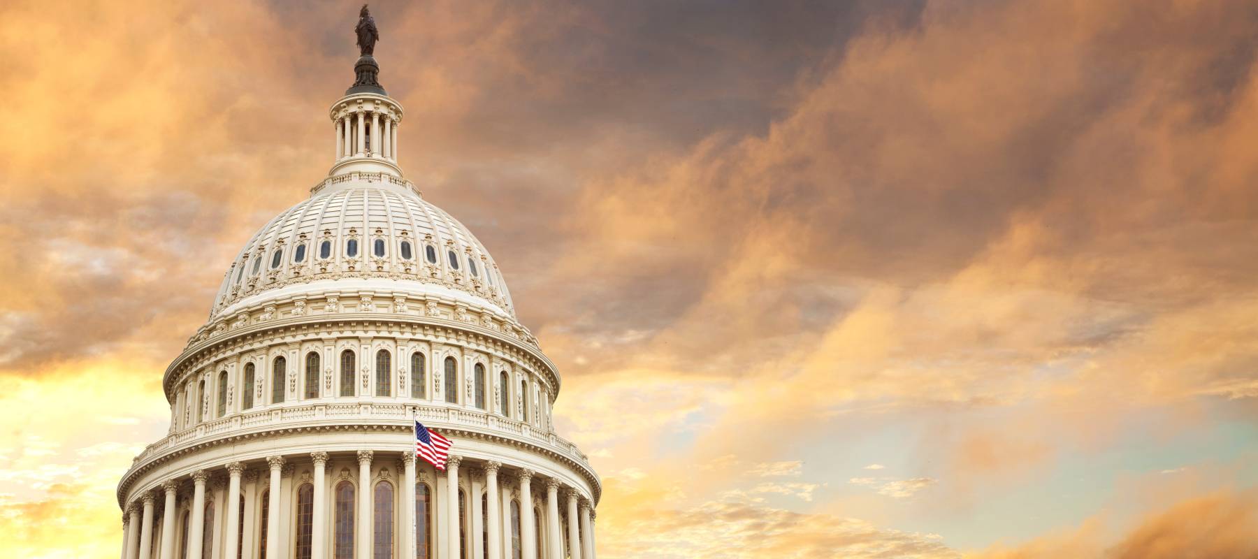 United States Capitol building with a fiery sky in the background.