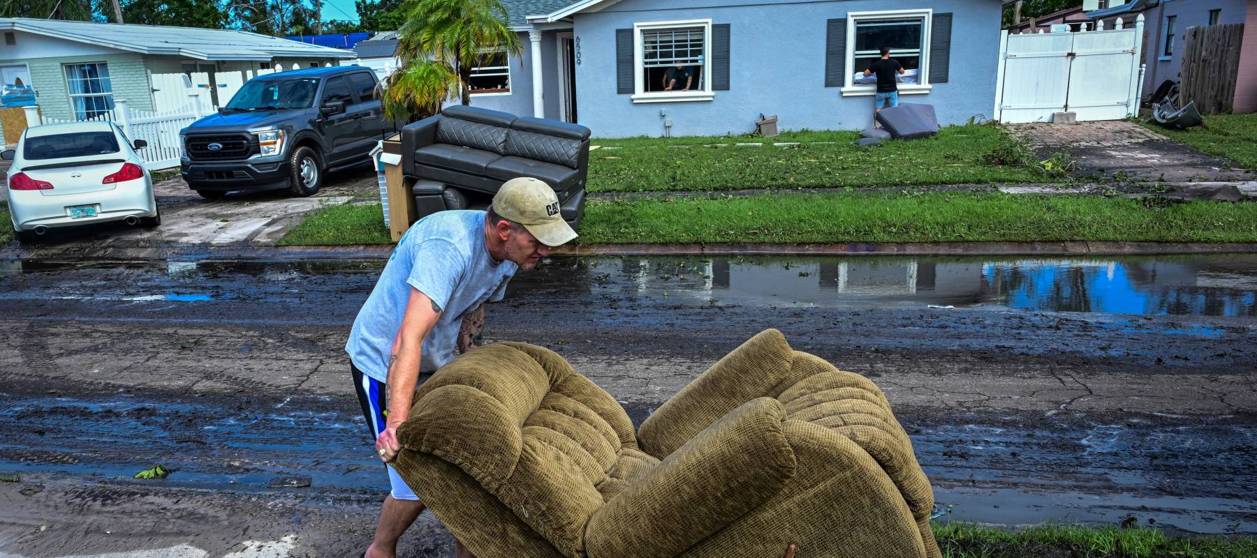 A man moves a chair in Tampa after Hurricane Milton.