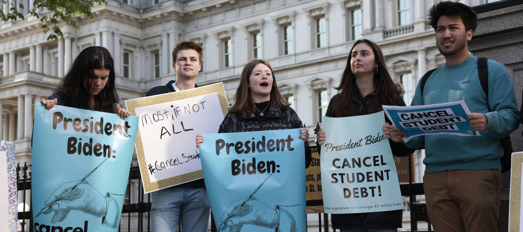 Activists hold signs as they attend a student loan forgiveness rally near the White House in Washington, D.C., April 27, 2022.