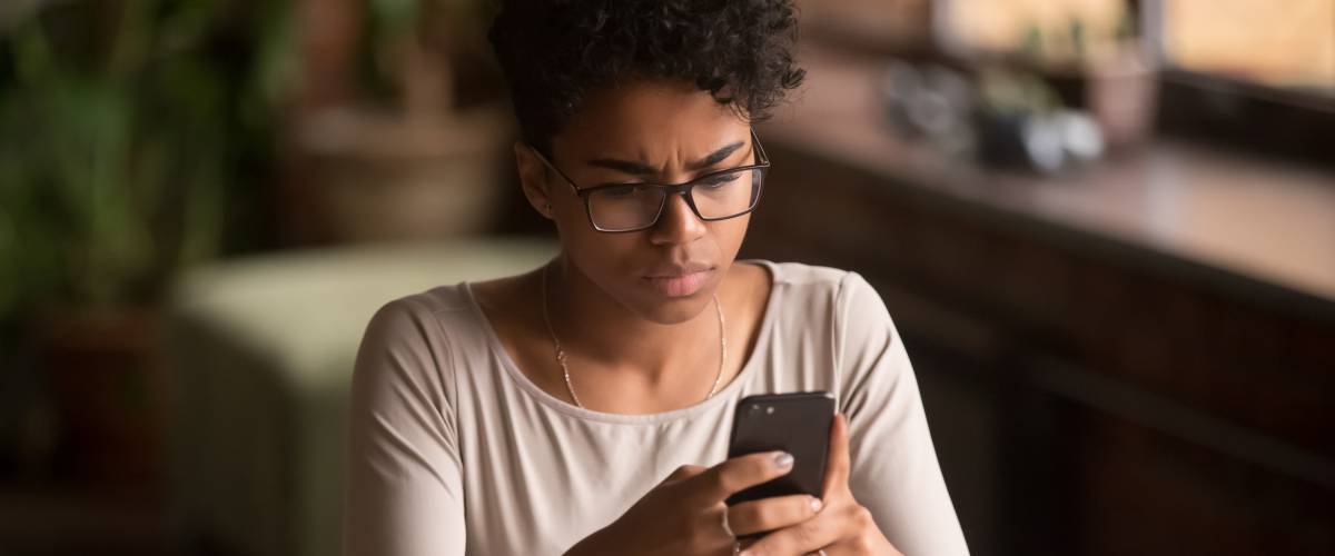Woman looking confusedly at cellphone