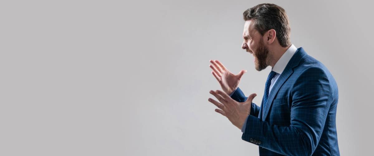 a Caucasian male boss yelling and gesturing, isolated against a grey background