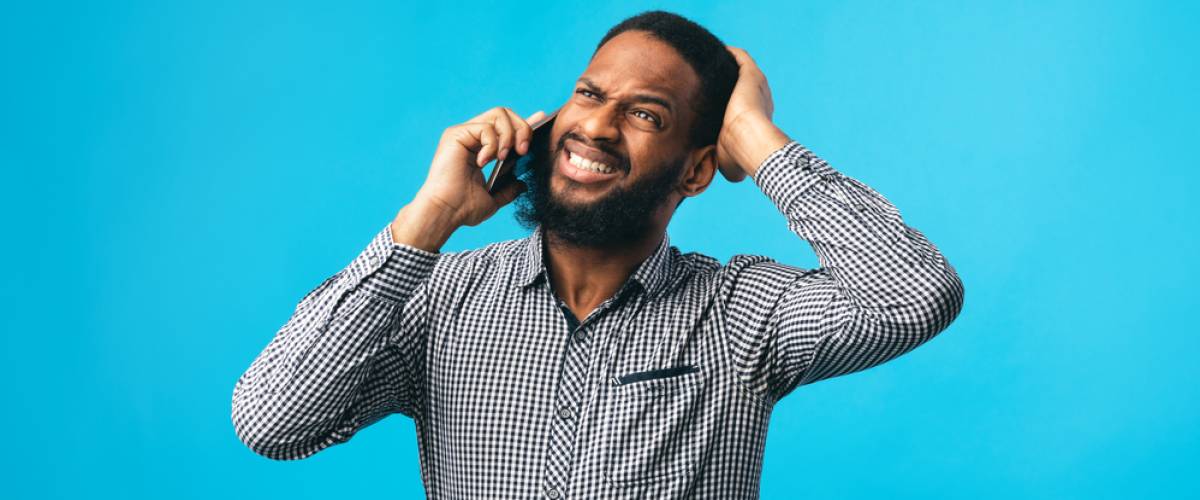disappointed black business man making phone call with hand on head
