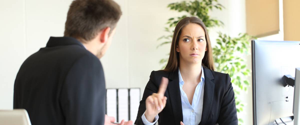 denying something saying no with a finger gesture to an upset employee in her office