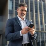 Successful mature hispanic senior business man using smartphone cellphone