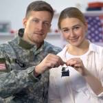 American male soldier and his wife holding house key reward for military service