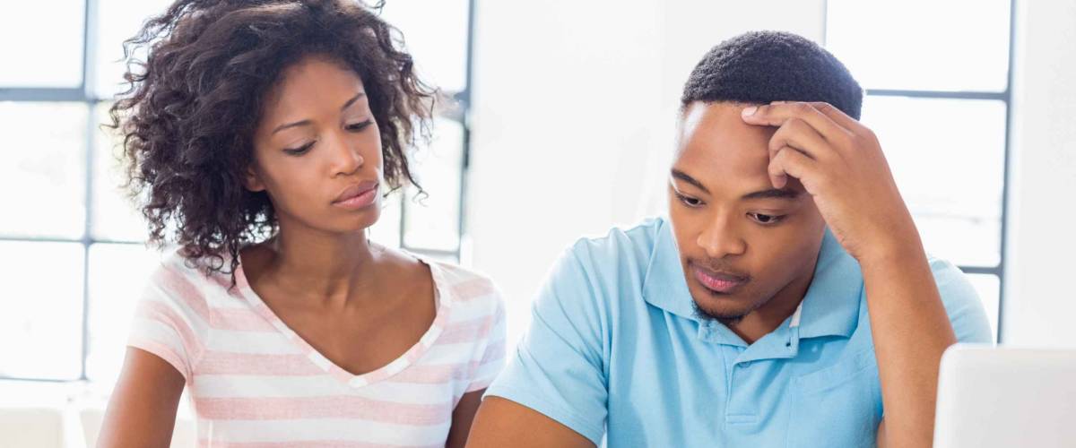 Worried young couple discussing bills at home