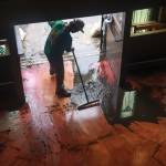 Austin Stolpe clears the mud from the floor of the Celtic Ray Public House restaurant/bar.