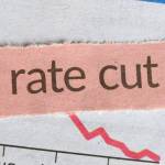 Fed rate cut written on a piece of tape over a graph
