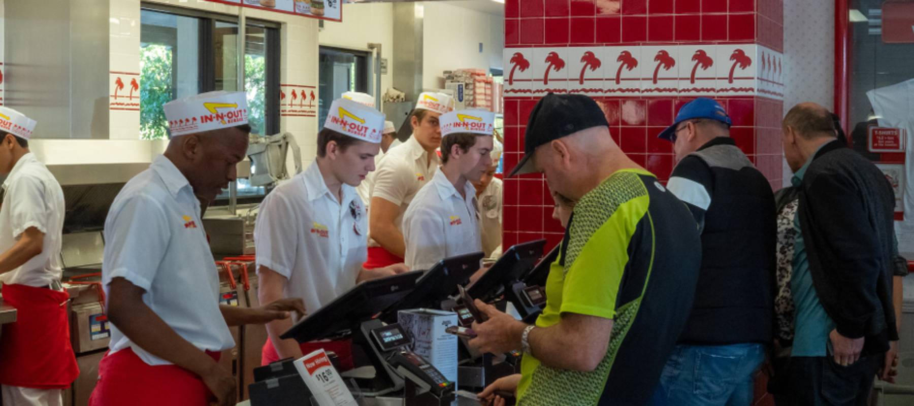 Diners lined up behind cashier and checkout counter at In-N-Out