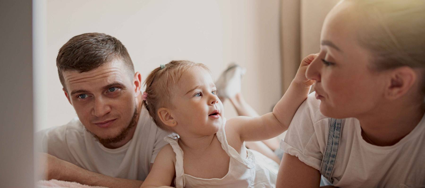 happy Caucasian family of three having fun together watching cartoons online