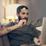 young man using a laptop on the sofa at home