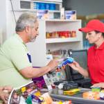 Senior paying at store with credit cad.