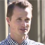 Man stands in front yard, talking directly to camera, upset.