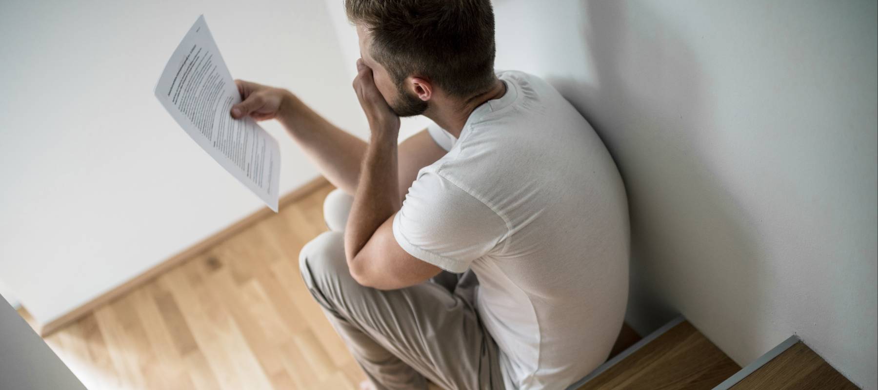Depressed young man at home worried about finances