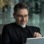Businessman using tablet computer in office lobby or on cafe terrace