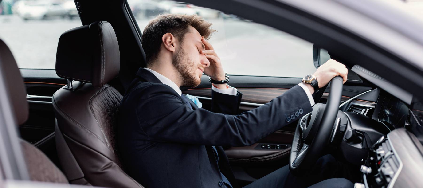 Young bearded business man sitting in car very upset and stressed