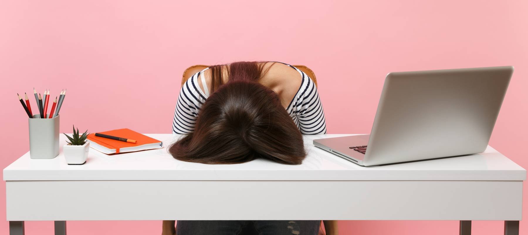 Young frustrated exhausted woman laid her head down on the table sit work at white desk with contemporary pc laptop