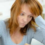 Lady using calculator, stressed